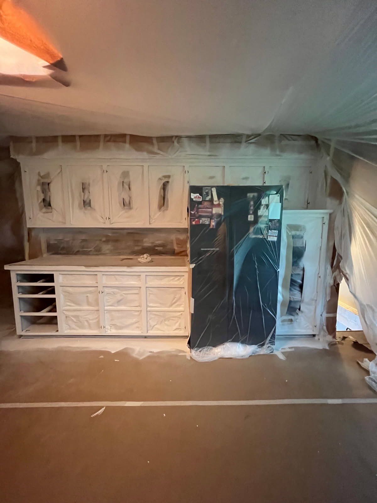 Kitchen tented in plastic for spraying cabinet boxes in place — EverPro Painting Kansas City